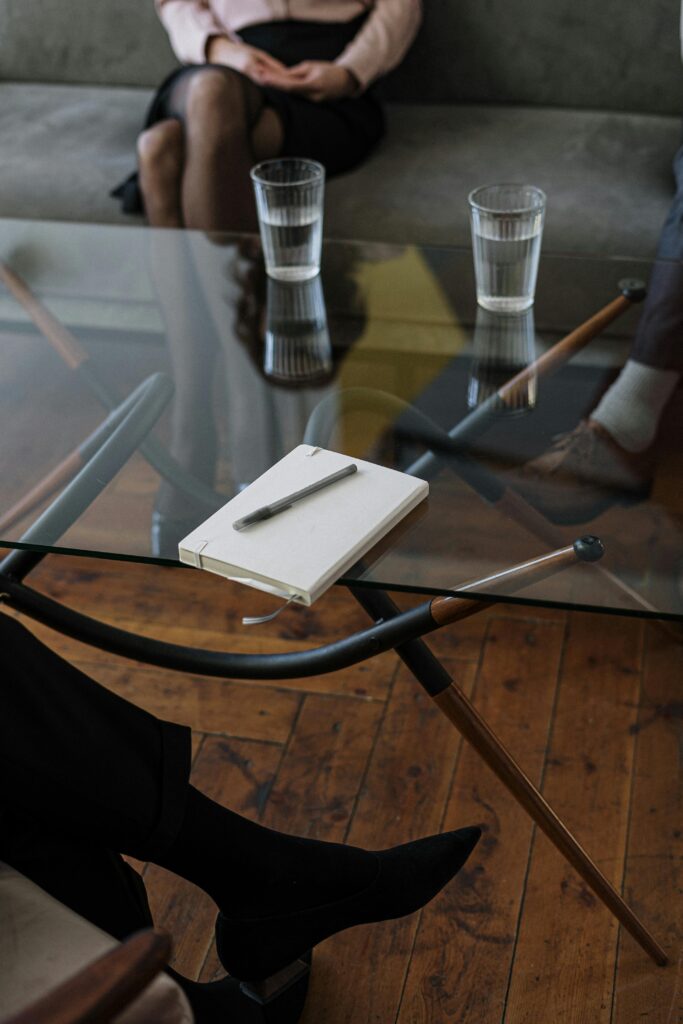 A glass desk with a notepad on top of it